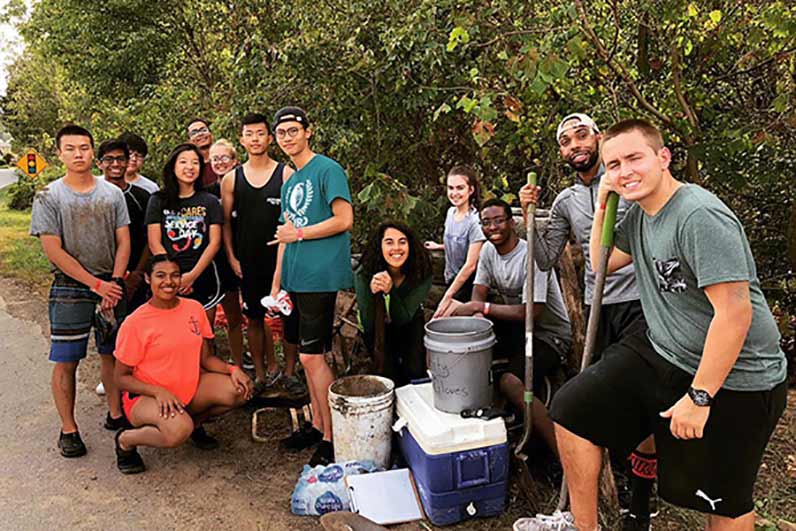 Students do outdoor clean up during an Alternative Fall Break service trip.