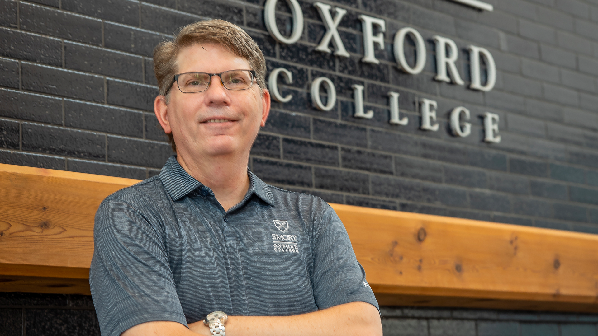 Oxford College Dean Doug Hicks in front of the Dining Hall fireplace